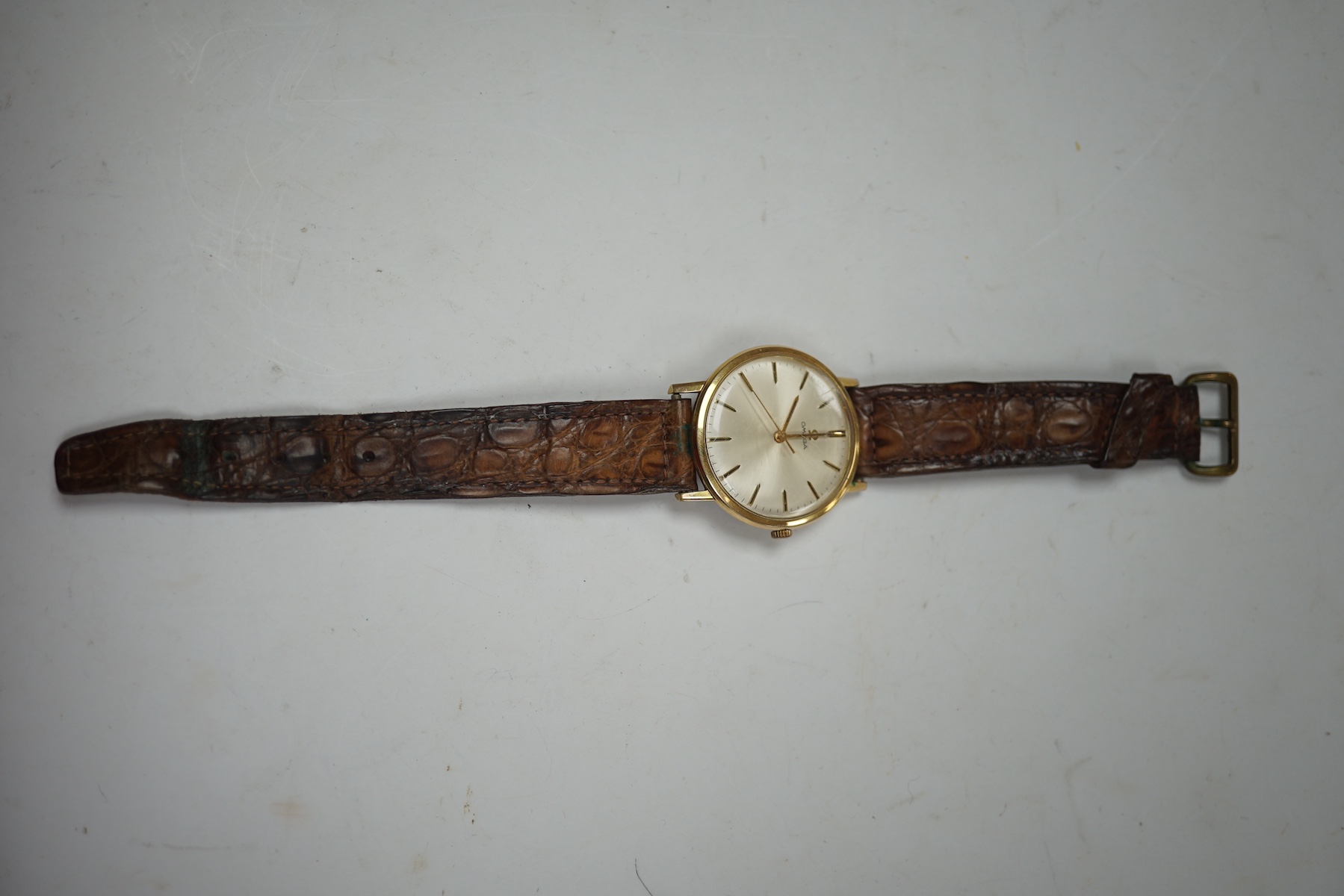 A gentleman's gold plated Omega manual wind wrist watch, on a leather strap, case diameter 34mm. Condition - Fair